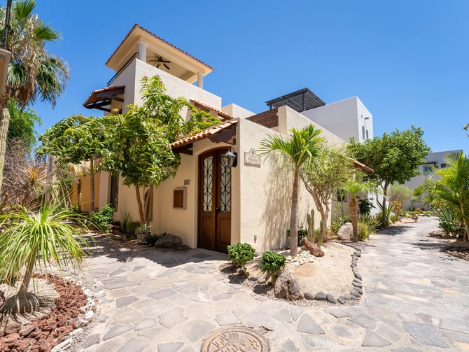 Stone path leading to the entrance of a Loreto Bay villa surrounded by palms and desert plants