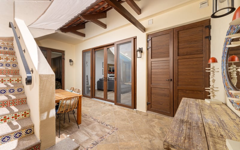 Covered patio with tiled staircase and outdoor dining
